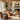 Wohnzimmer in einem Landhasusstil der Inneneinrichtung. Mit Kamin, Esstisch und 2 Sesseln 