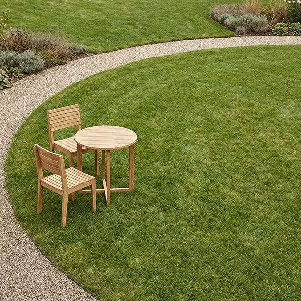 Holz-Essgruppe im Garten am Rasen neben Kiesweg mit Beeten